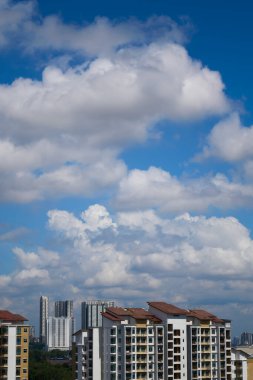 Modern Asya şehrinin gökdelenleri yeşil ağaçların üzerinde yükseliyor.
