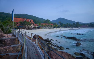 Turistler, Malezya 'nın Redang Adası' ndaki bir tatil beldesinin önünde kumsalda güzel bir akşam geçiriyorlar.