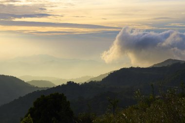 Gün batımında sisli ve yumuşak ışıkla dağların manzarası