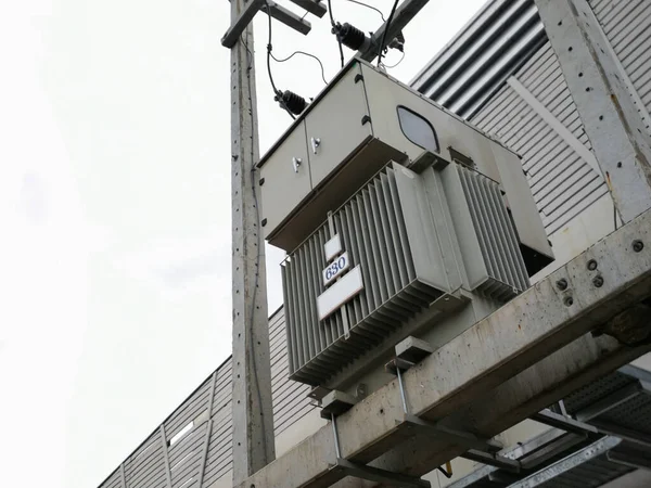 Three phase (630 kVA) electric current transformer mounted on the electric pole, on a white background.