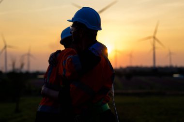 Technician working outdoor at wind turbine field. Environmental engineer research and develop approaches to providing clean energy sources