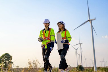 Technician working outdoor at wind turbine field. Environmental engineer research and develop approaches to providing clean energy sources