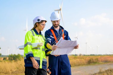 Technician working outdoor at wind turbine field. Environmental engineer research and develop approaches to providing clean energy sources
