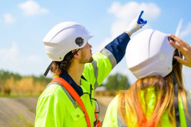 Technician working outdoor at wind turbine field. Environmental engineer research and develop approaches to providing clean energy sources