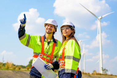 Technician working outdoor at wind turbine field. Environmental engineer research and develop approaches to providing clean energy sources