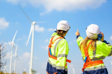 Technician working outdoor at wind turbine field. Environmental engineer research and develop approaches to providing clean energy sources