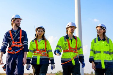 Technician working outdoor at wind turbine field. Environmental engineer research and develop approaches to providing clean energy sources