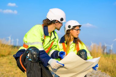 Technician working outdoor at wind turbine field. Environmental engineer research and develop approaches to providing clean energy sources