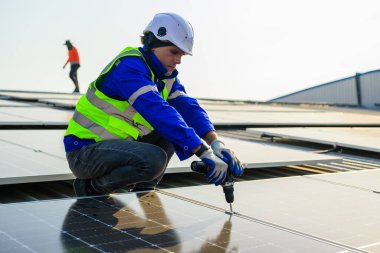 Professional technicians installing solar panels on rooftop of plant, Workers checking and operating system at solar cell farm power plant, Renewable energy source for electricity and power, Solar