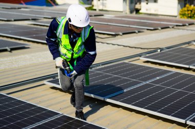 Professional engineer technician with safety helmet checking and operating system at solar cell farm power plant, Renewable energy source for electricity and power, Solar cell maintenance concept