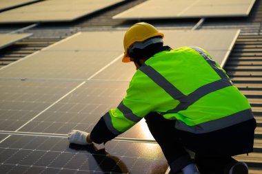 Professional engineer technician with safety helmet checking and operating system at solar cell farm power plant, Renewable energy source for electricity and power, Solar cell maintenance concept