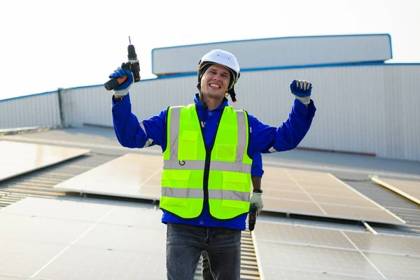 Happy engineers technicians installing solar panels on rooftop of plant, Workers checking and operating system at solar cell farm power plant, Renewable energy source for electricity and power