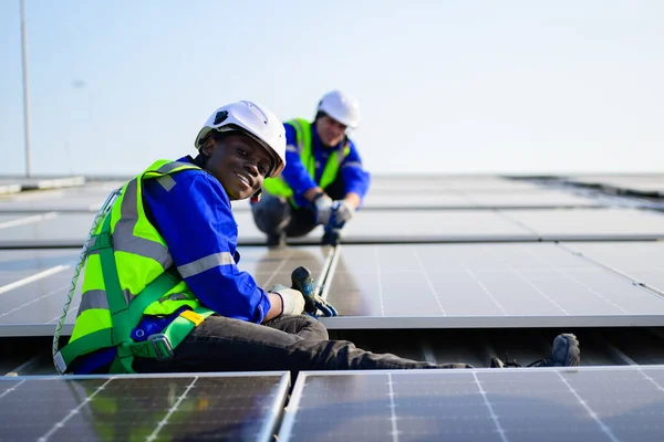 Professional technicians installing solar panels on rooftop of plant, Workers checking and operating system at solar cell farm power plant, Renewable energy source for electricity and power, Solar