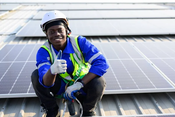 Smiling portrait of happy engineer technician working on rooftop of solar cell farm power plant, Renewable energy source for electricity and power, Solar cell maintenance concept