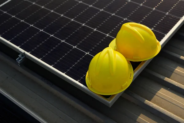 Yellow safety helmets or yellow hard hats on solar panels at solar cell farm power plant, Renewable energy source for electricity and power, Clean energy