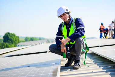 Professional engineer technician with safety helmet checking and operating system at solar cell farm power plant, Renewable energy source for electricity and power, Solar cell maintenance concept