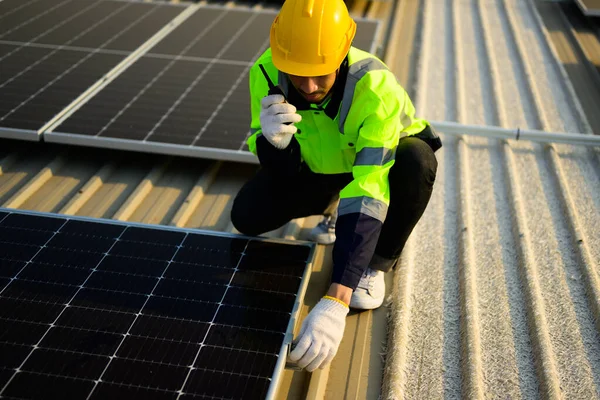 Engineer and technician checking and operating solar panels system on rooftop of solar cell farm power plant, Renewable energy source for electricity and power, Solar cell maintenance concept