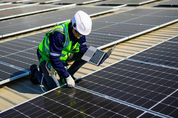 Güneş pili tarım santralinin çatısında dizüstü bilgisayar kontrol ve işletim sistemi kullanan mühendis teknisyeni, elektrik ve elektrik için yenilenebilir enerji kaynağı, güneş pili bakım konsepti