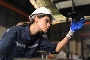 Confident female technician engineer worker checking and inspecting machine at manufacturing factory, Machinery maintenance concept