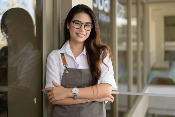 Smiling portrait of young barista business owner at retail coffee shop, People opening shop, High quality photo