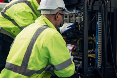 Robotics engineers team discussing and solving problems working together in manufacturing automation factory, Industry robot programing software for automated manufacturing technology