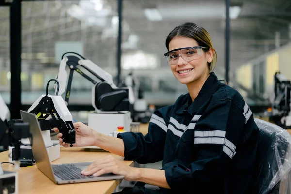 工业工厂使用手提电脑检查和操作自动化机器人的女技师 工厂使用机器人系统的女工 — 图库照片