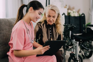 Young doctor or nurse visiting happy senior patient at home, People with medical service at home, Health care concept