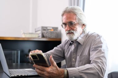 Senior grandfather using laptop and smart phone at home, Happy retirement people relaxing and resting at home, Healthy and happy senior people concept
