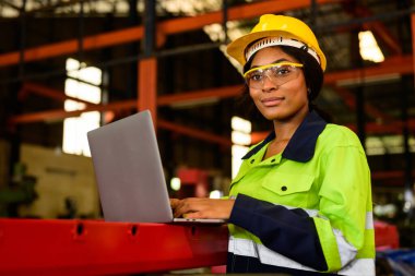 Technician engineer holding robot controller checking and repairing automatic robotic machine at industrial factory, Worker working with robotic arm system in factory