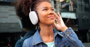 Portrait of smiling happy woman walking in street with backpack, Young tourist travel in city, Curly hair, Attractive, Summer vacation, Traveler, Cheerful, Positive, High quality photo