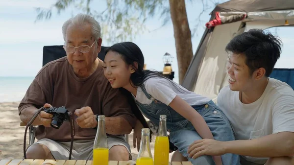 Happy Asian family with barbecue party at camping beach together, Cooking grilled barbecue for dinner during camping on summer beach, High quality photo