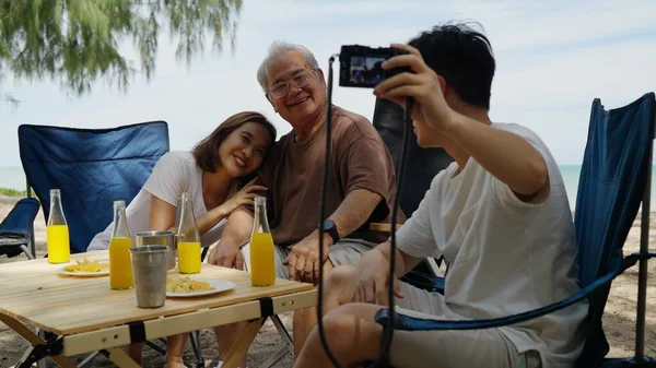 Happy Asian family with barbecue party at camping beach together, Cooking grilled barbecue for dinner during camping on summer beach, High quality photo