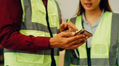 Two warehouse workers with safety helmet working together at factory, Engineers talking and working in storage, Warehouse manager and worker working with teamwork