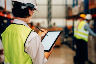 Warehouse supervisor using tablet for controlling and checking goods supplies on shelves with goods background in warehouse store, Logistic and business export concept