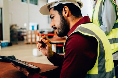 Warehouse staff using tablet for checking list of work, Hardworking male engineer working at warehouse factory