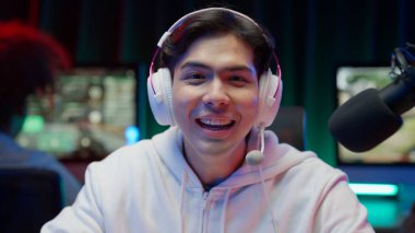 Professional game streamer using pc setup playing game talking on headset while explaining gameplay to subscribers, Teenager streaming online action game while sitting on chair, High quality photo