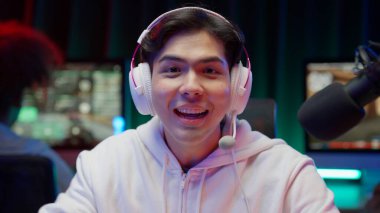 Professional game streamer using pc setup playing game talking on headset while explaining gameplay to subscribers, Teenager streaming online action game while sitting on chair, High quality photo