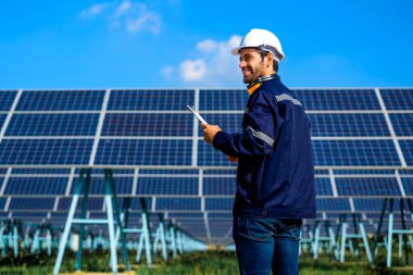 Güneş çiftliğinde güneş paneli ile çalışan mühendis portresi, güneş pili analizi yapan mühendis işçilerle güneş çiftliği, yenilenebilir enerji mühendisleri yenilenebilir ya da sürdürülebilir enerji üretimi