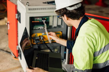 Technician engineer checking and repairing automatic robotic machine at industrial factory, Worker working at production line machine system in factory