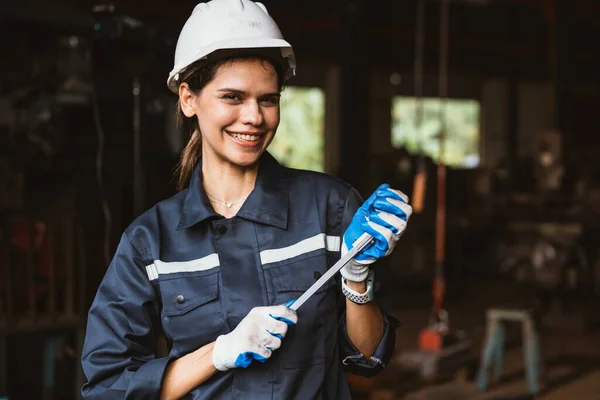 Portrait of happy female industrial worker in white hard hat smiling working at manufacturing plant, Industrial engineer portrait