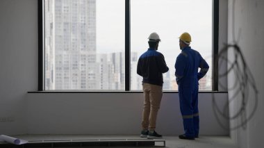 Professional contractor with safety helmet talking and brainstorming with electrician technician engineer at workplace, Technician engineer foreman discussing with team at building site