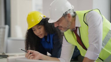 Professional construction engineers team using blueprint of project plan brainstorming and working together at construction building, Architecture and building construction concept