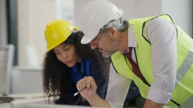 Professional construction engineers team using blueprint of project plan brainstorming and working together at construction building, Architecture and building construction concept