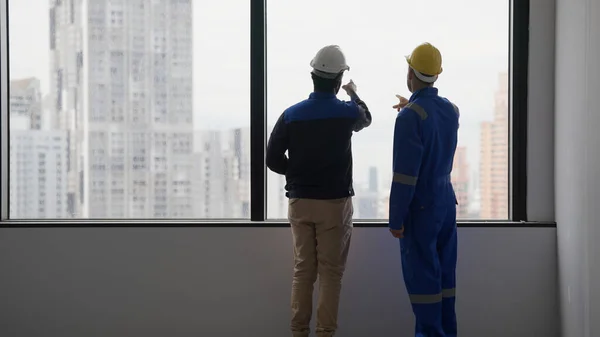 持有安全帽的专业承包商在工作场所与电工技师工程师交谈和集思广益 技师工程师工头在建筑工地与团队讨论 — 图库照片