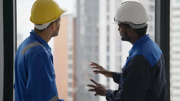 持有安全帽的专业男性承包商在工作场所与电工技师工程师交谈和集思广益 技师工程师工头在建筑工地与团队讨论 — 图库照片
