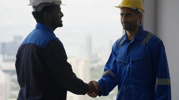 construction workers shaking hands at construction site, Handshake between engineer foreman manager and electrician, Construction workers with teamwork concept