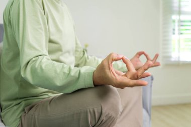 Senior yoga pose, Senior doing yoga in living room, Elderly setting on sofa and doing yoga exercise