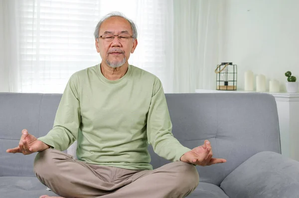 Senior yoga pose, Senior doing yoga in living room, Elderly setting on sofa and doing yoga exercise
