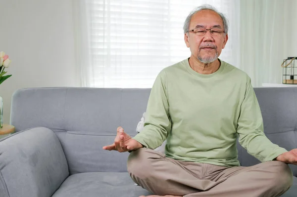 Senior yoga pose, Senior doing yoga in living room, Elderly setting on sofa and doing yoga exercise