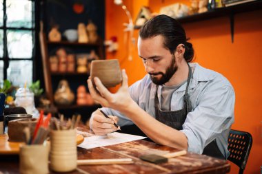 Professional craftsman potter making jug of clay on the potters wheel circle in workshop, Traditional handicraft working, Creativity and art of pottery